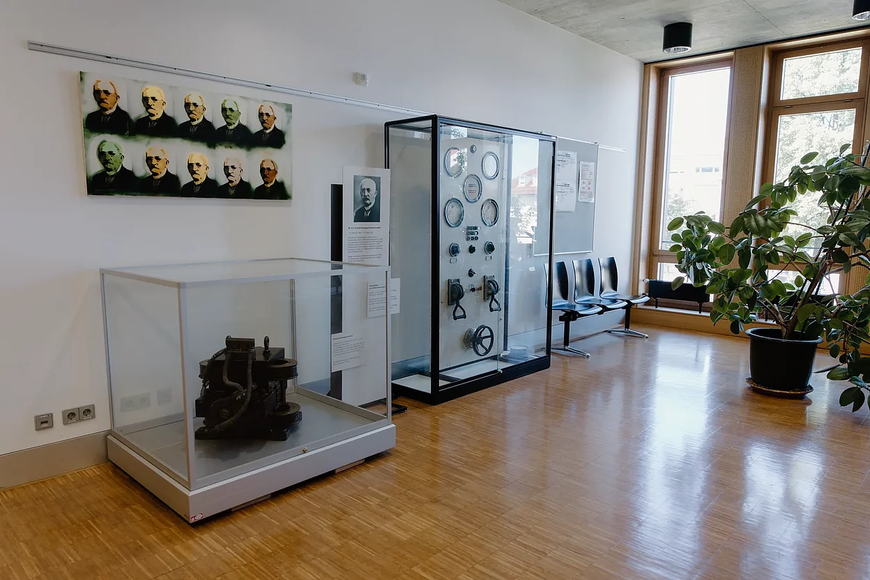 Das Foto zeigt den Wartebereich vor dem Schülersekretariat. Es gibt Sitzgelegenheiten und Vitrinen mit Ausstellungsstücken zum Namensgeber der Schule: Friedrich August Haselwander.