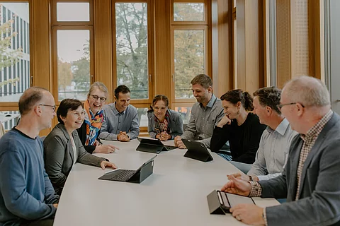 Das Foto zeigt das gesamte Schulleitungsteam an einem Tisch.