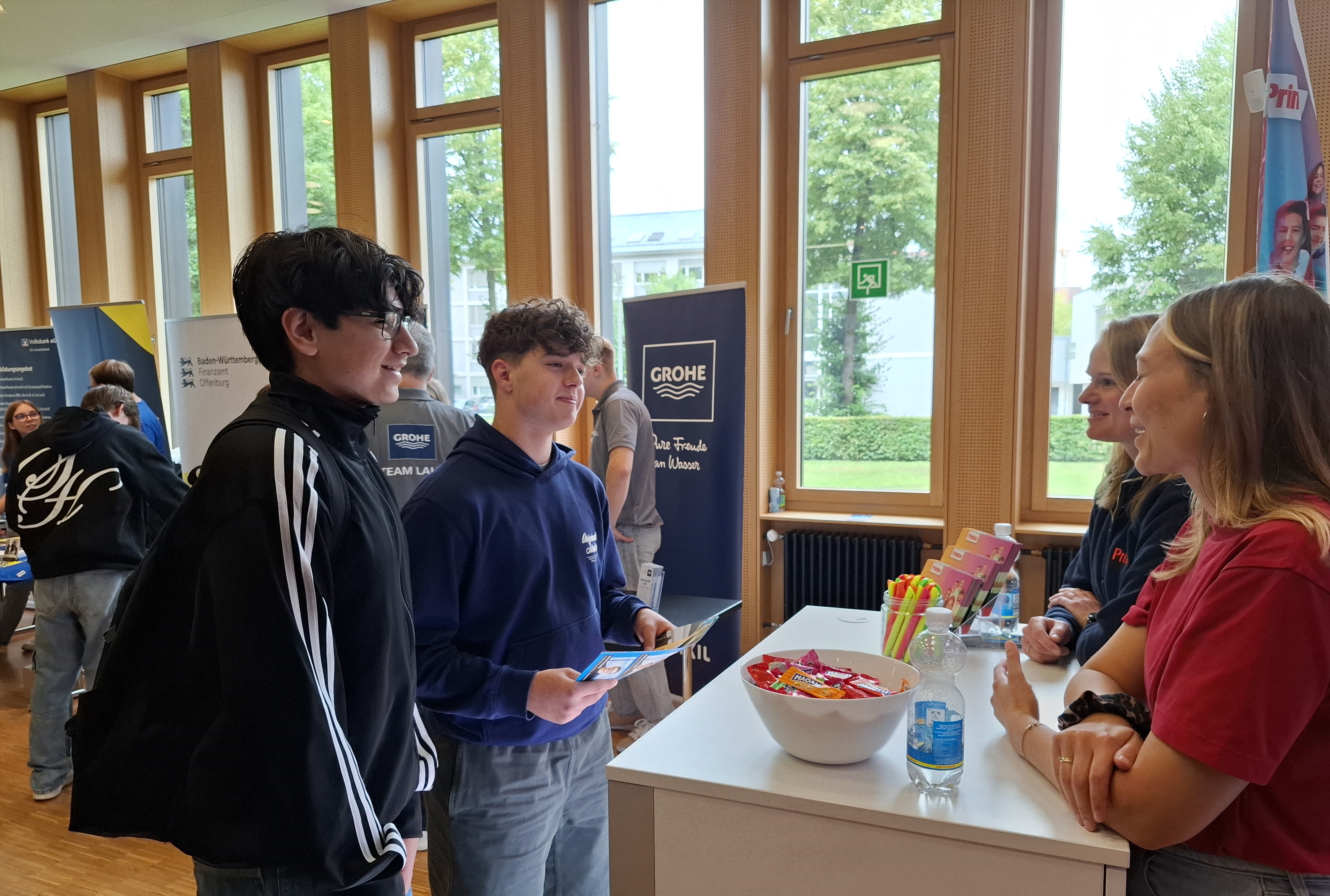 Das Foto zeigt Schüler im Gespräch mit einem Aussteller der Berufsinfomesse in unserer Schule.