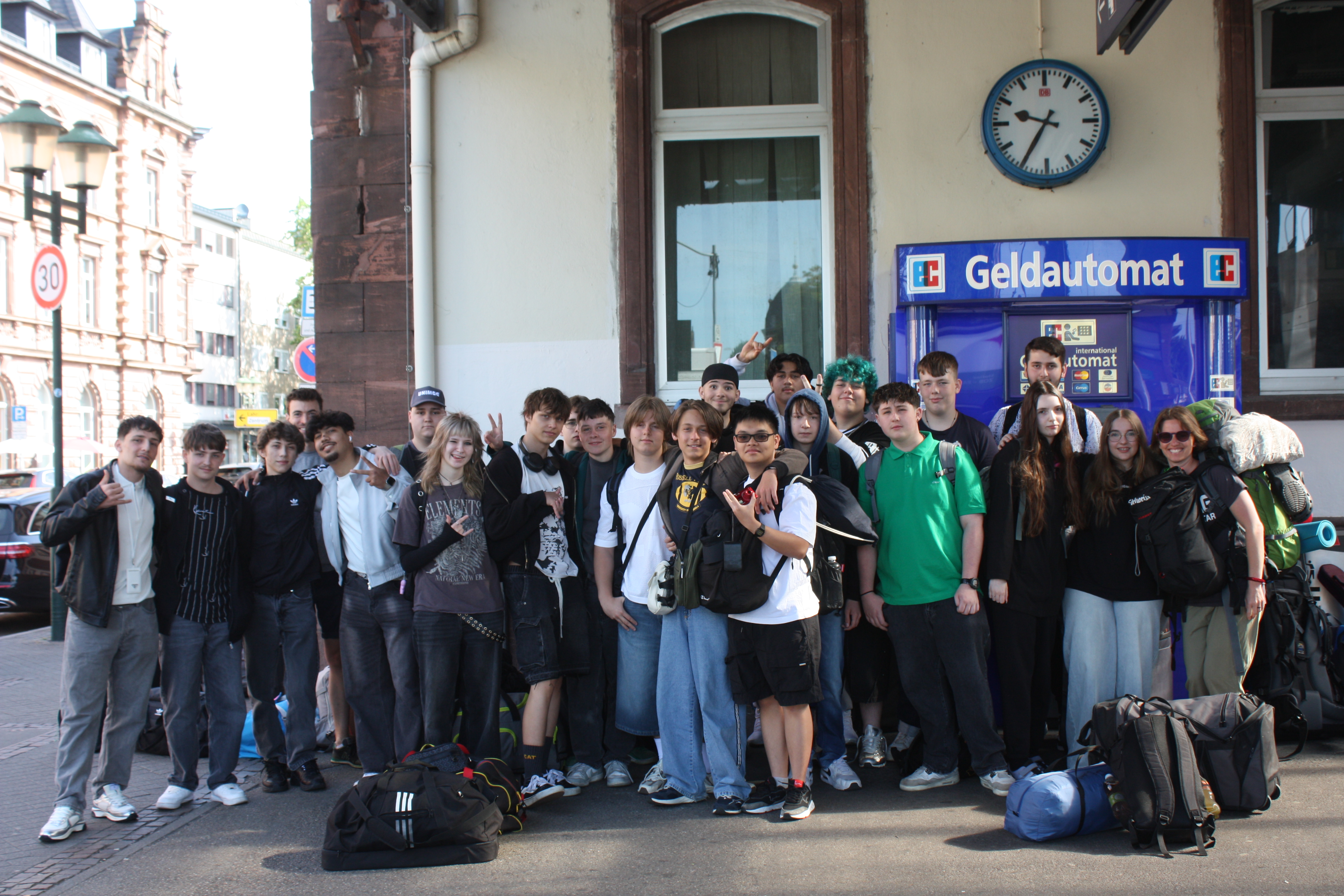 Das Foto zeigt die Klasse 1BSAV4 im Schuljahr 2025 / 2026, wie sie als Gruppe für ein Foto am Bahnhof posiert.